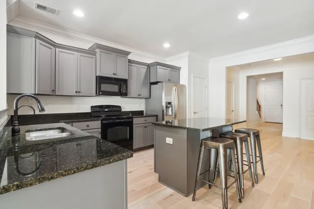 a kitchen with a refrigerator a sink and white cabinets