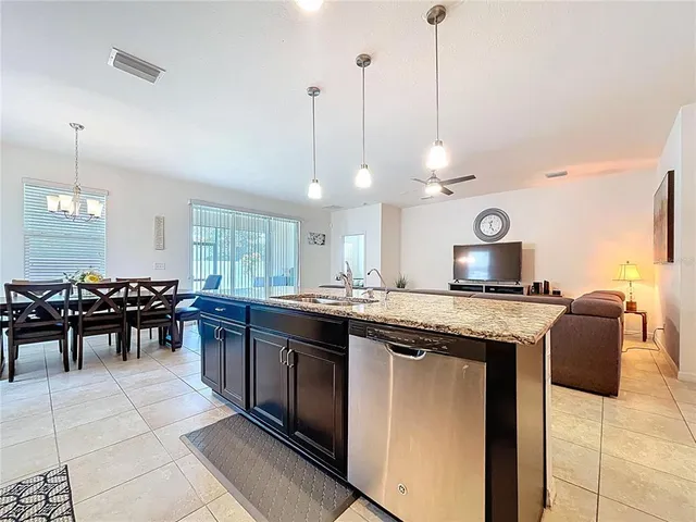 a bedroom with a bed a chair and a flat tv screen on the dresser