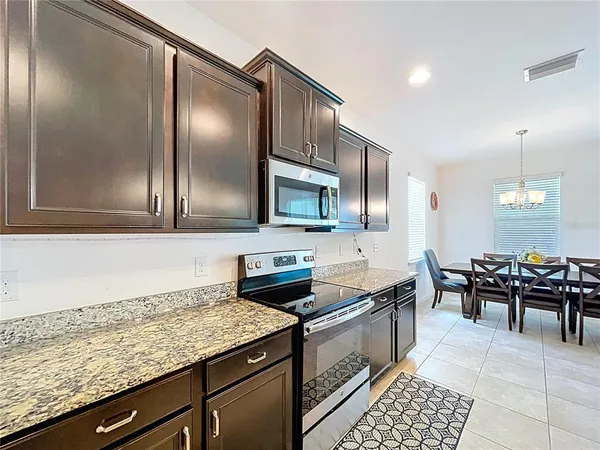 a spacious bedroom with a bed lamp and a chandelier