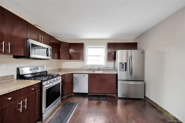 a kitchen with granite countertop a refrigerator stove top oven and sink