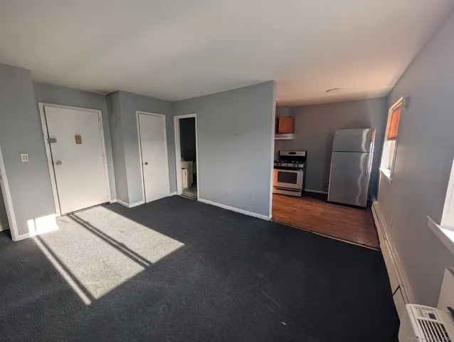a view of an empty room and a kitchen
