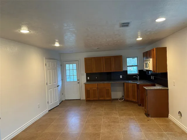 a large kitchen with lot of cabinets and stainless steel appliances