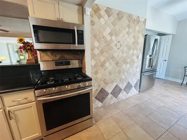 a kitchen with granite countertop a stove and a microwave