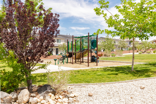 3157 Deseret Drive St. George, UT 84790 - Photo 24 of 24 Park area featuring a playground structure with slides and climbing elements, surrounded by a wood chip surface