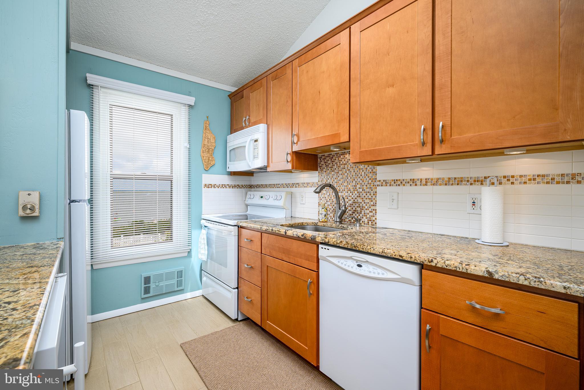 24 Joan Road Long Beach Township, NJ 08008 - Photo 12 of 66 a kitchen with stainless steel appliances granite countertop a sink a stove and a microwave