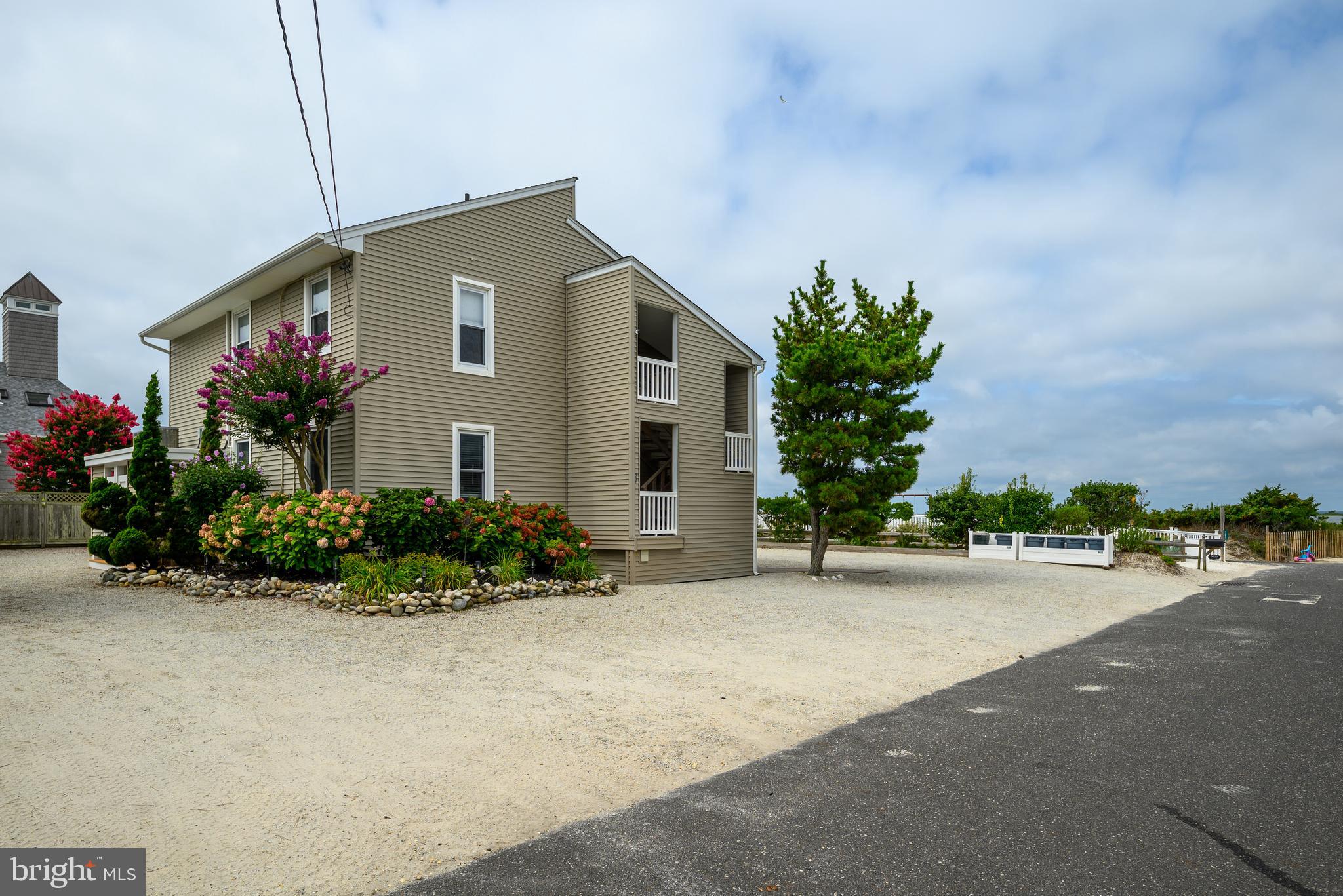 24 Joan Road Long Beach Township, NJ 08008 - Photo 3 of 66 a front view of a house with a yard and potted plants