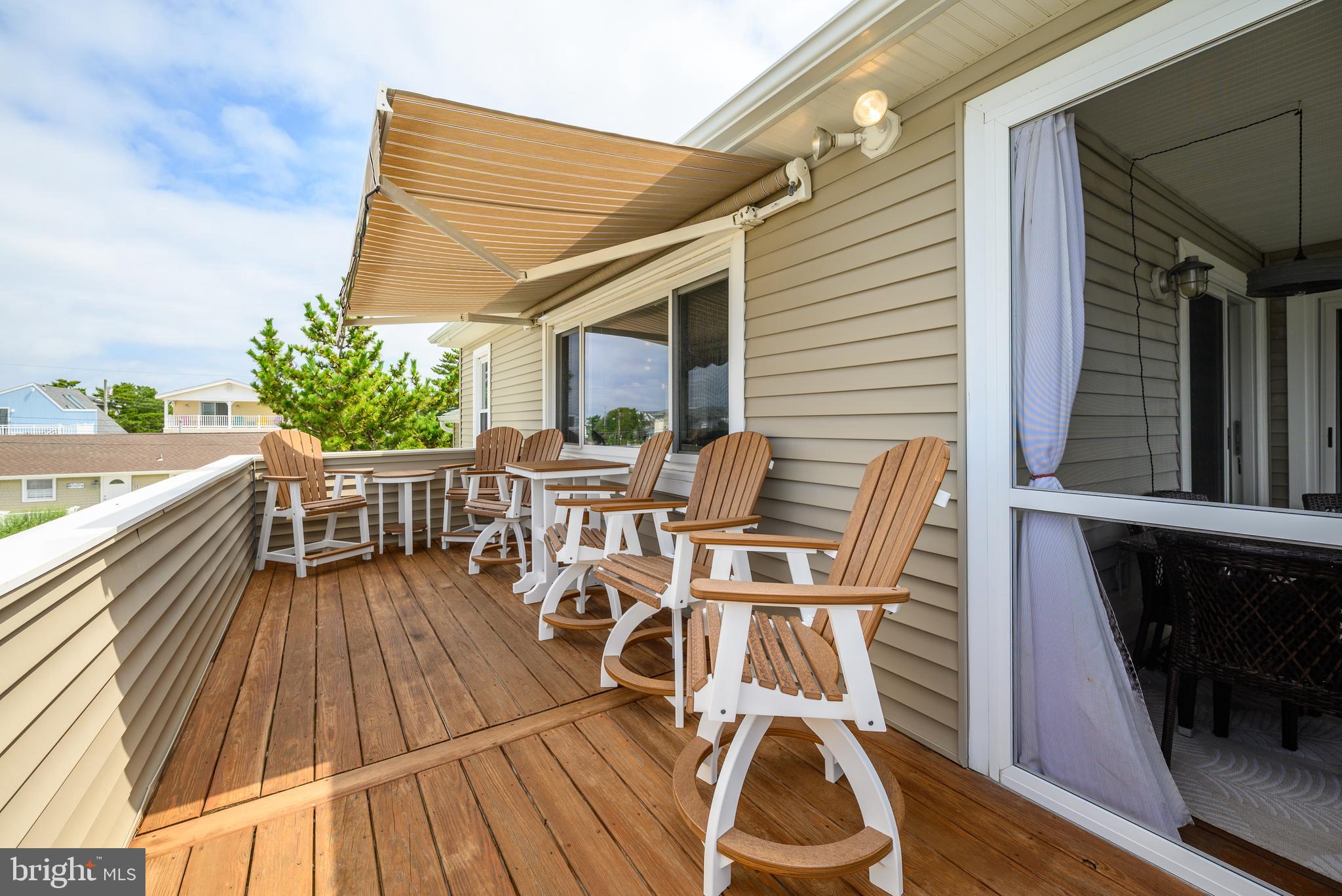 24 Joan Road Long Beach Township, NJ 08008 - Photo 37 of 66 a view of a patio with table and chairs with wooden floor and fence