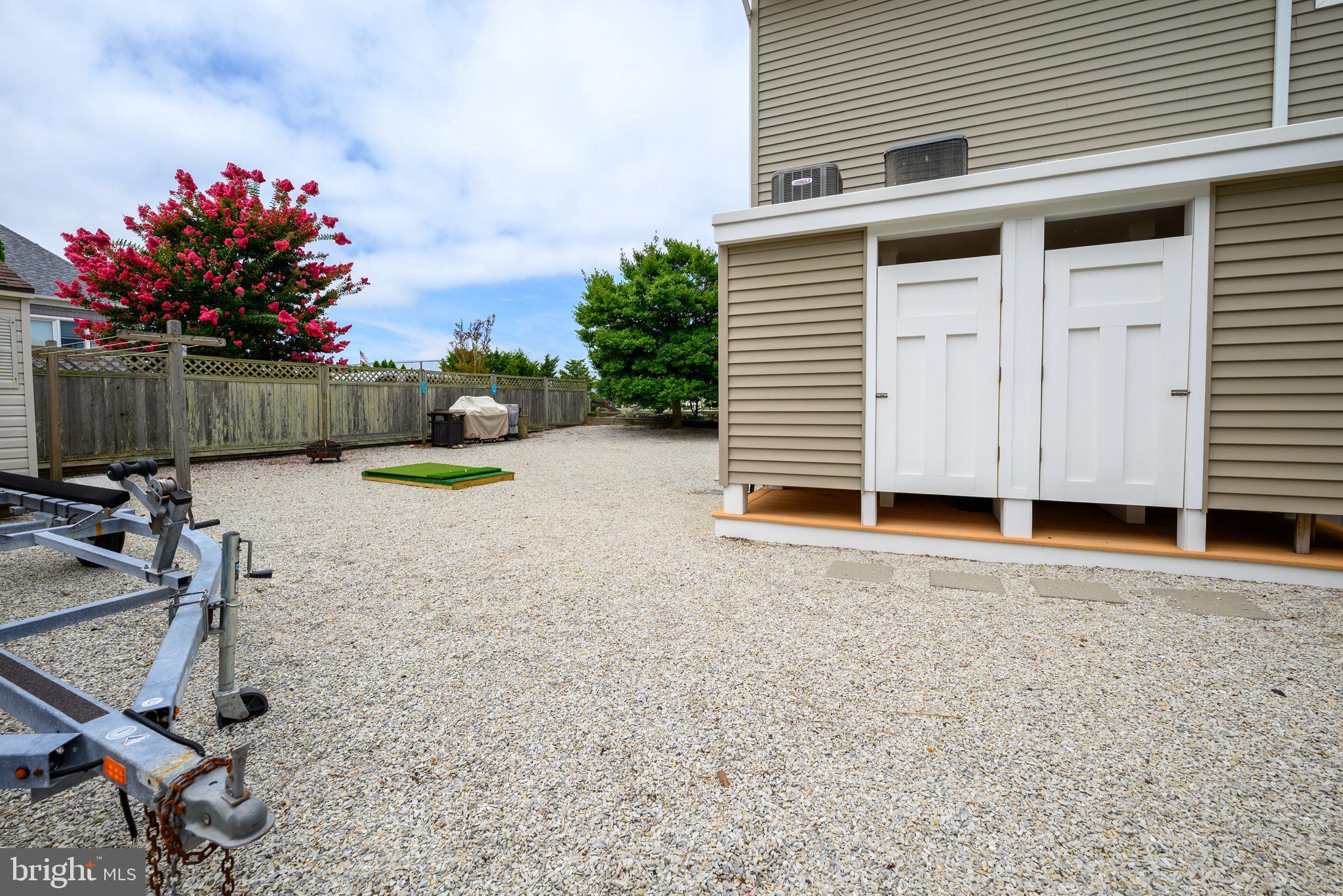 24 Joan Road Long Beach Township, NJ 08008 - Photo 38 of 66 a view of a backyard with a chair and potted plants