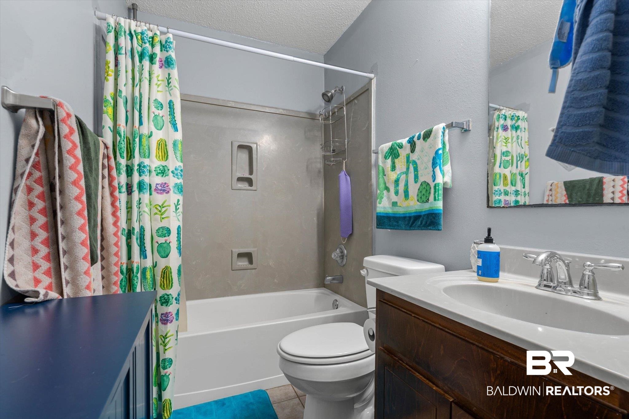 14165 River Oaks Road, Unit A & B Coden, AL 36523 - Photo 20 of 35 Full bathroom featuring shower / tub combo with curtain, a textured ceiling, vanity, and light tile patterned floors
