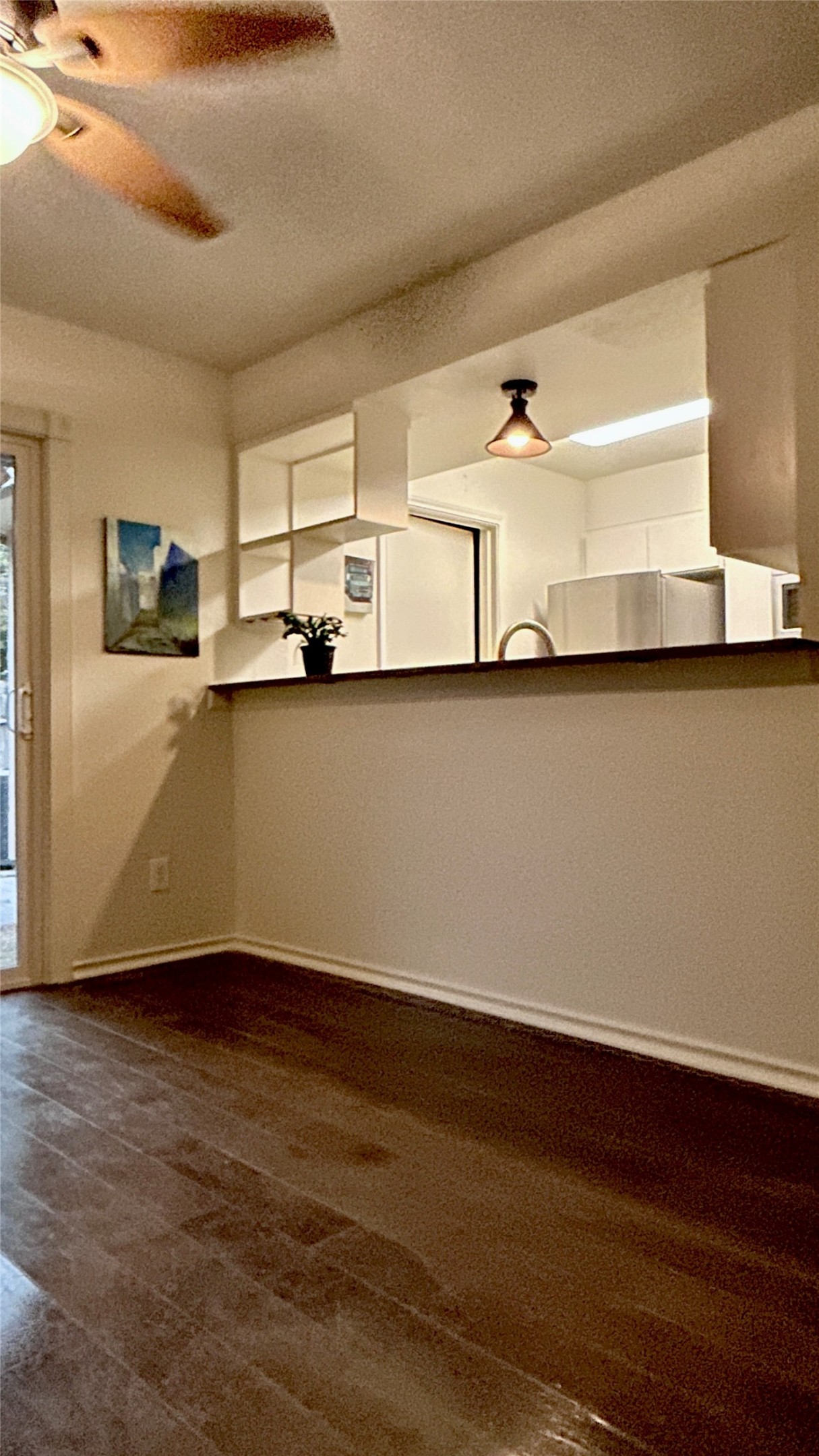 Rich wood-look flooring anchors this inviting space featuring a practical breakfast bar pass-through.
