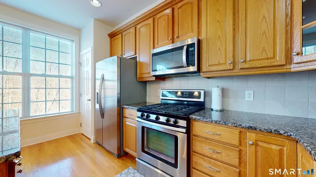 a kitchen with stainless steel appliances granite countertop a stove microwave and cabinets