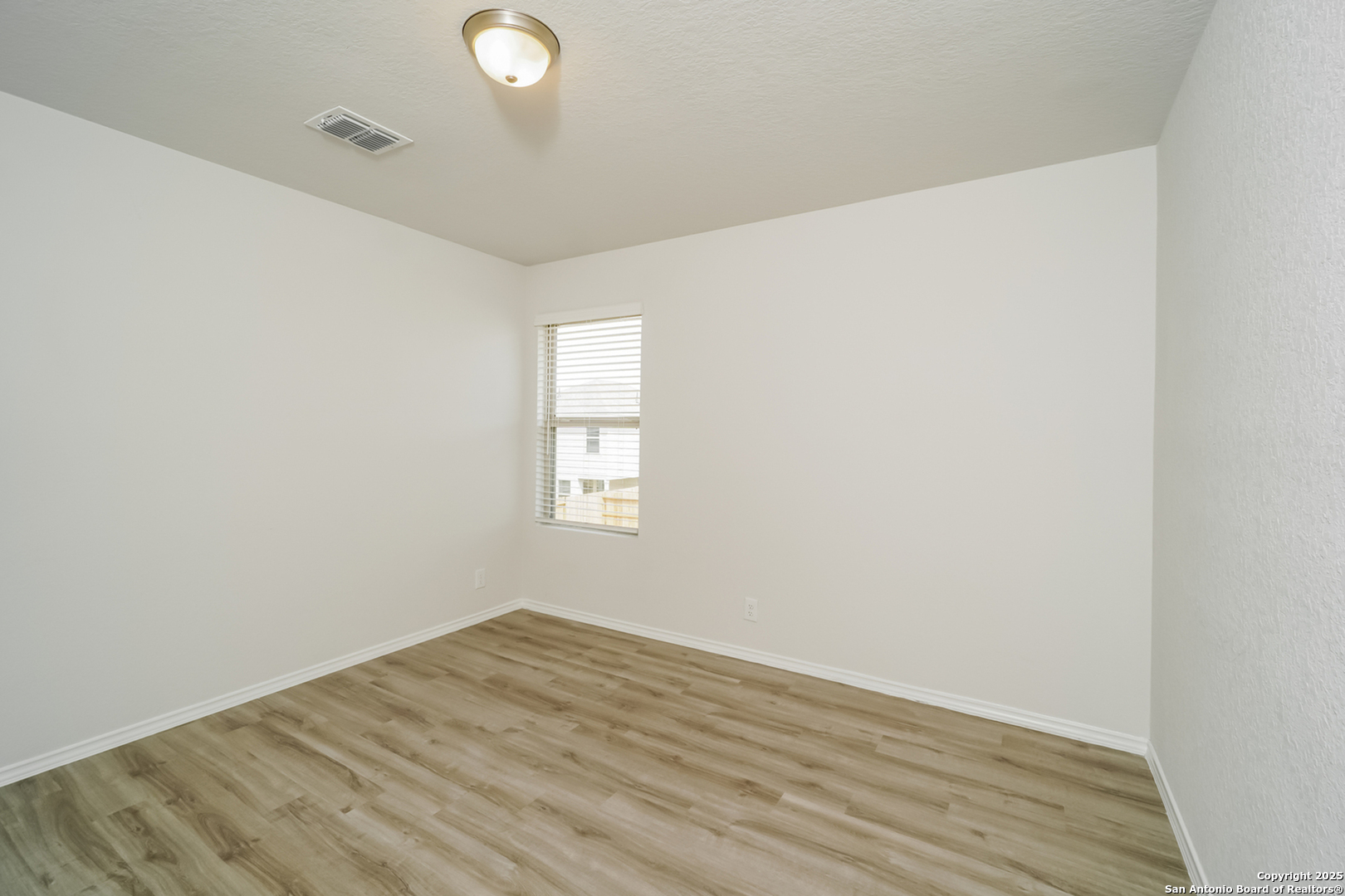 5130 Blue Ranch San Antonio, TX 78222 - Photo 13 of 17 an empty room with wooden floor and windows
