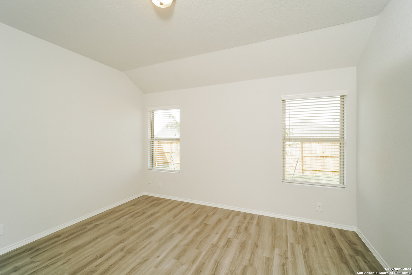 5130 Blue Ranch San Antonio, TX 78222 - Photo 9 of 17 an empty room with wooden floor and windows