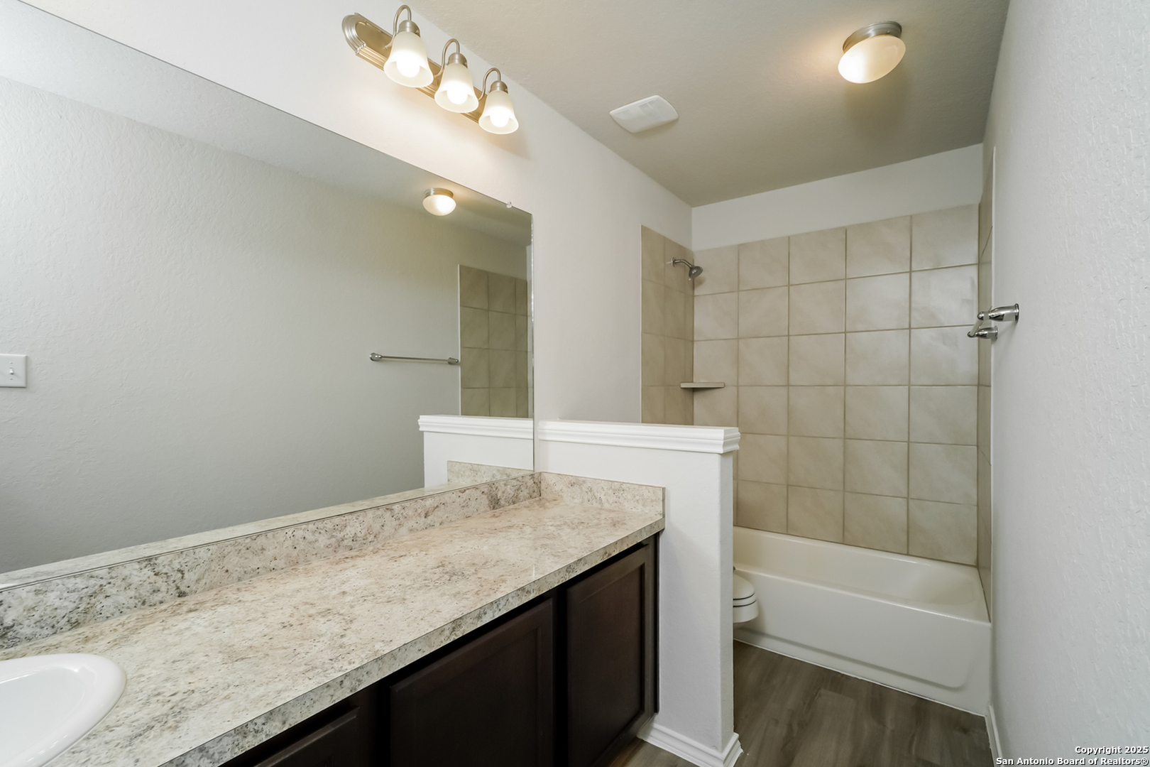 5130 Blue Ranch San Antonio, TX 78222 - Photo 10 of 17 a bathroom with a granite countertop sink a toilet and bathtub