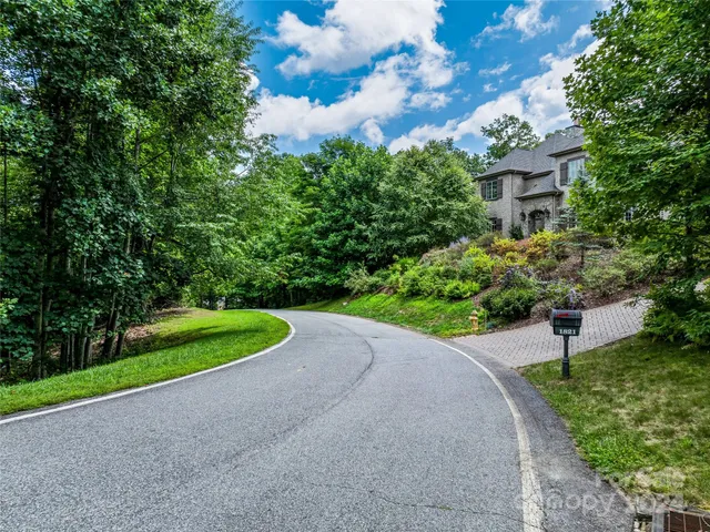 a view of a house with a yard and potted plants