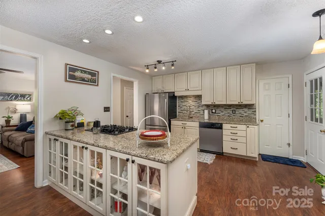 a kitchen that has a lot of cabinets a sink and appliances in it