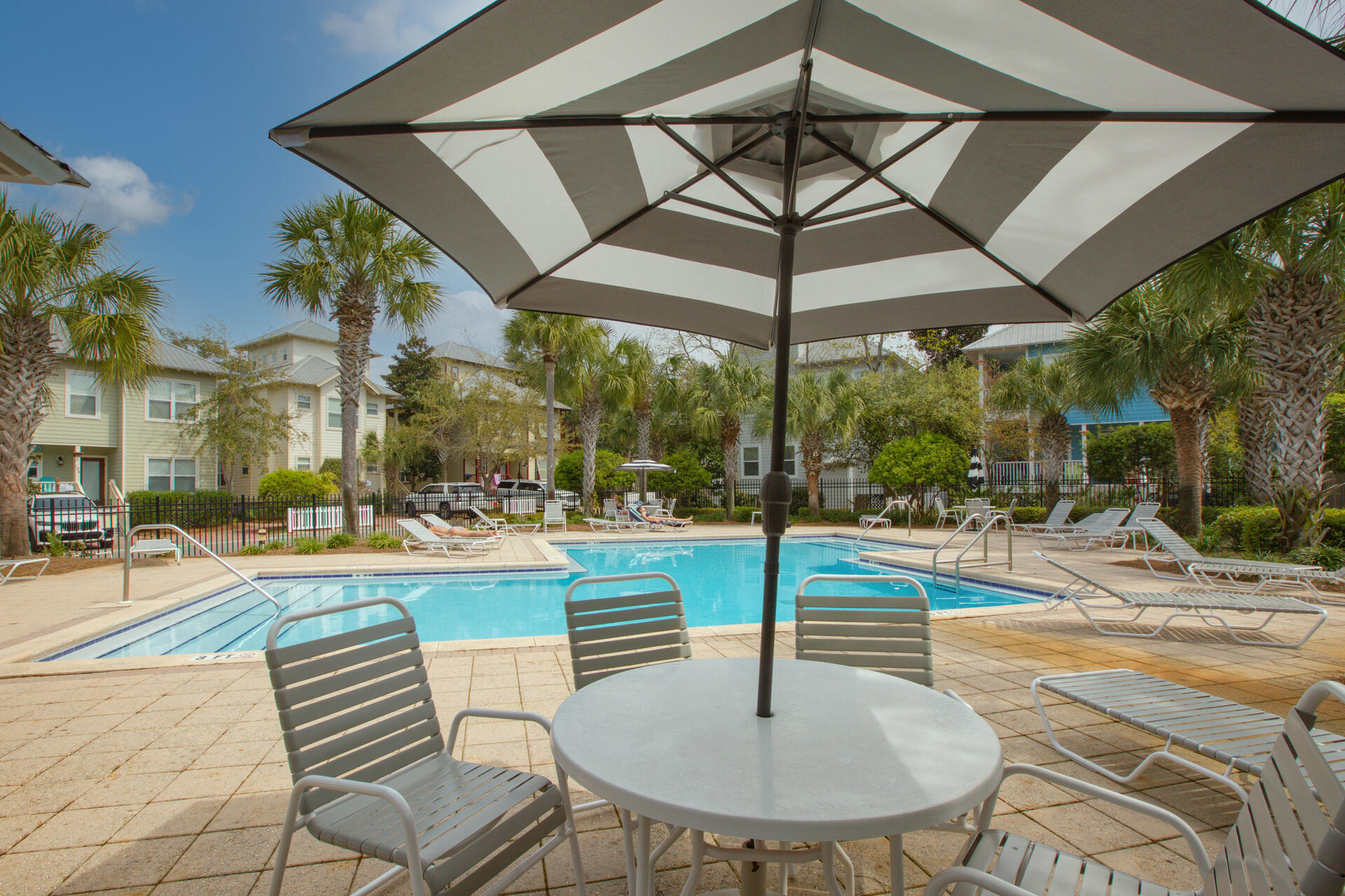183 Hidden Lake Way Santa Rosa Beach, FL 32459 - Photo 45 of 50 a view of a swimming pool with a table and chairs under an umbrella