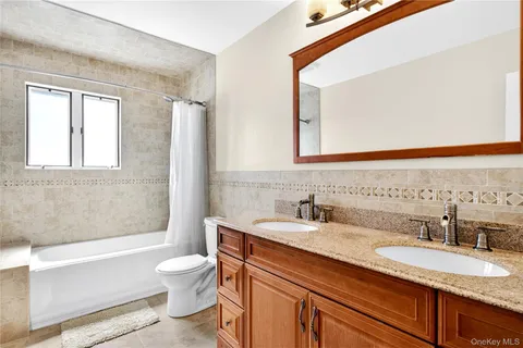 a bathroom with a granite countertop toilet a sink and a bathtub