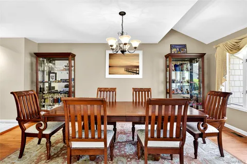 a view of a dining room with furniture wooden floor and a chandelier