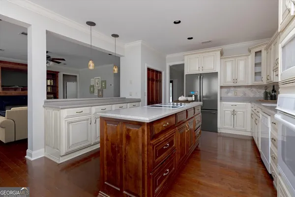 a kitchen with stainless steel appliances granite countertop a stove a sink and white cabinets with wooden floor