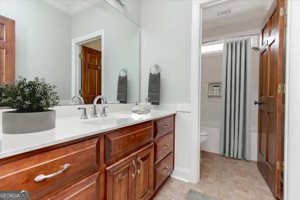 a view of a house with a yard and large tree