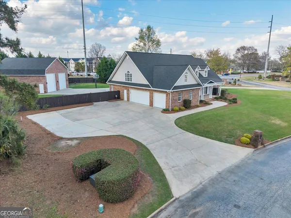 a aerial view of a house with a big yard potted plants and large tree
