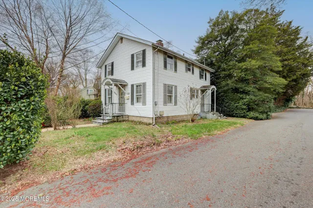 an aerial view of residential houses with outdoor space and trees