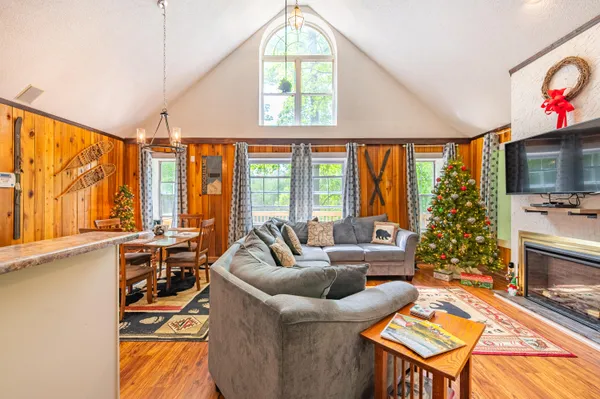 a living room with furniture a flat screen tv and a large window