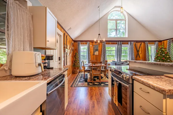 a kitchen with stainless steel appliances a stove a sink and a large window