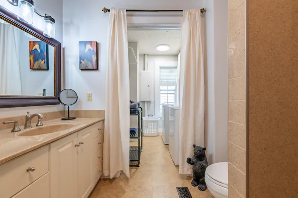 a bathroom with a granite countertop sink a mirror and a shower