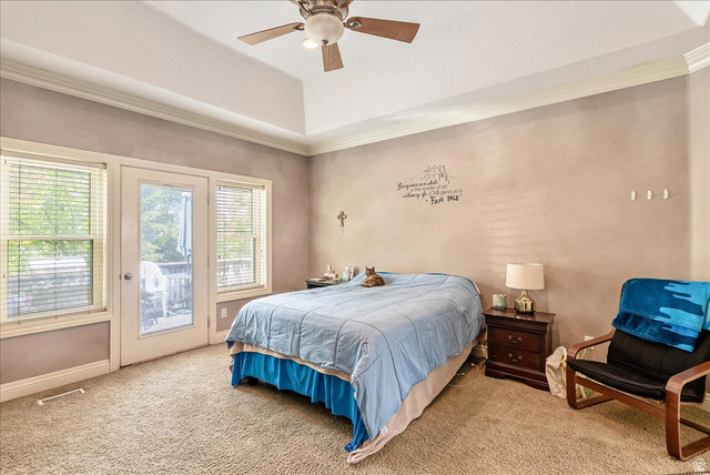 316 Azure Circle Draper, UT 84020 - Photo 21 of 48 Spacious bedroom featuring a tray ceiling, ceiling fan, carpet flooring, direct outdoor access through a glass-paneled door, and two adjacent windows