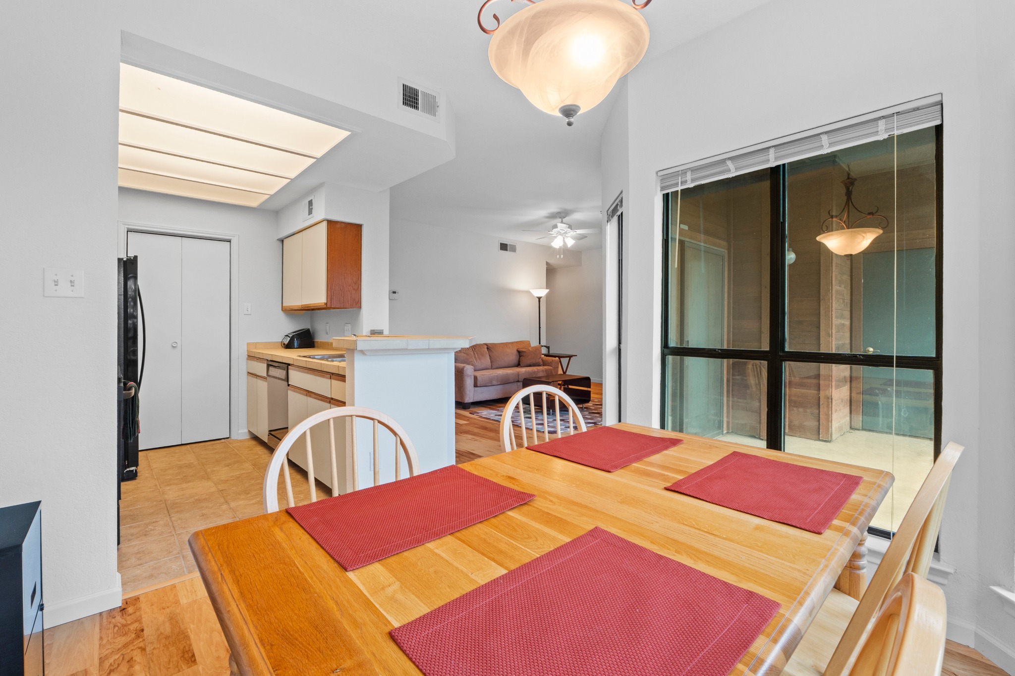 4711 Spicewood Springs Road, Unit 8146 Austin, TX 78759 - Photo 7 of 17 Dining space featuring wood-finish flooring, a contemporary ceiling light fixture, and a large window