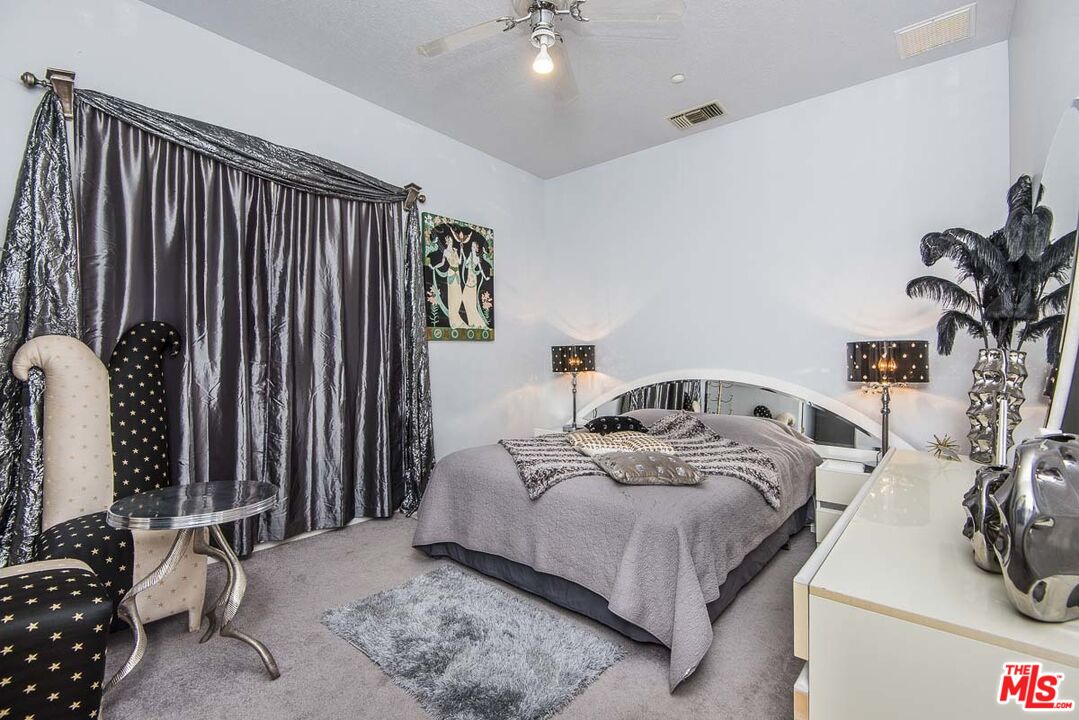 3569 Calmada Road Pioneertown, CA 92268 - Photo 12 of 18 a bedroom with a bed and a chandelier