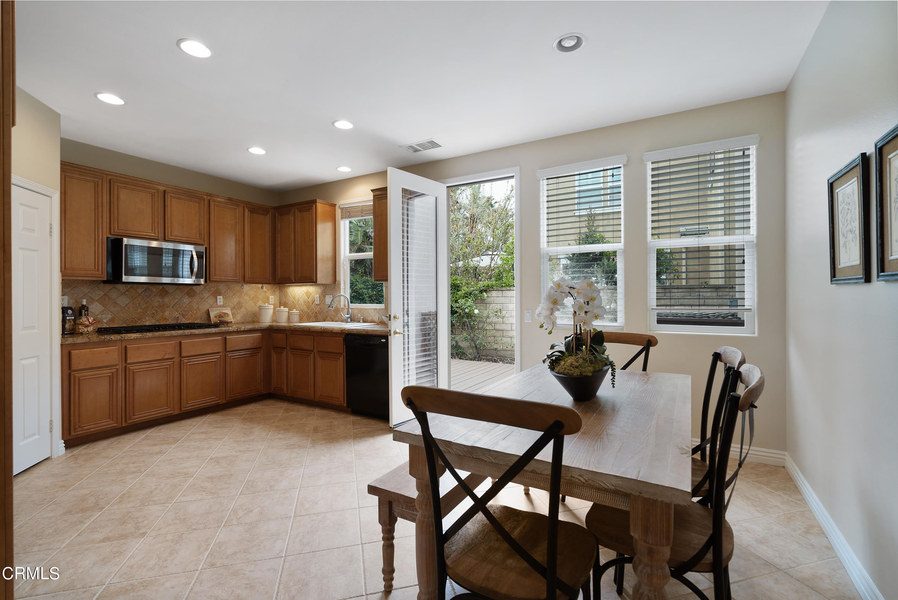 551 Spring Park Road Camarillo, CA 93012 - Photo 8 of 36 a kitchen with a table chairs refrigerator microwave and cabinets