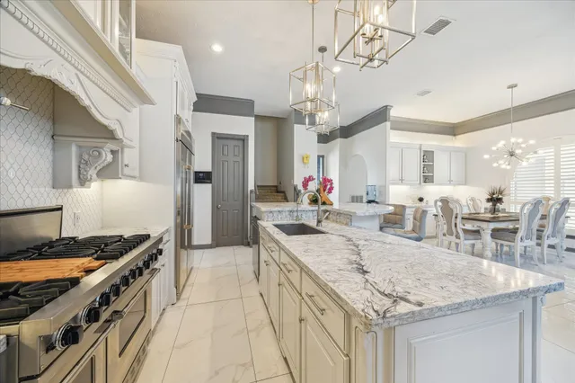 a kitchen with stainless steel appliances kitchen island granite countertop a table and chairs in it