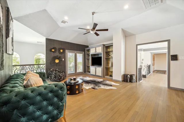 a living room with furniture a ceiling fan and a window