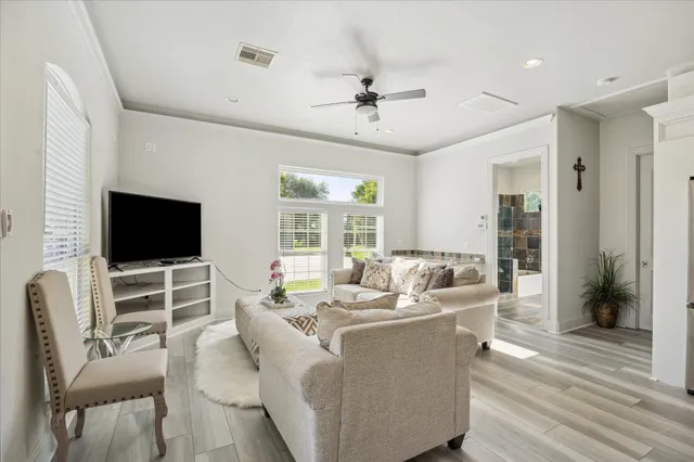 a kitchen with stainless steel appliances kitchen island granite countertop a refrigerator a stove a dining table and chairs with wooden floor