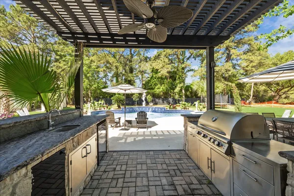 a view of a swimming pool with lawn chairs under an umbrella