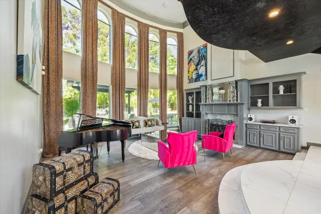 a living room with furniture a flat screen tv and floor to ceiling window