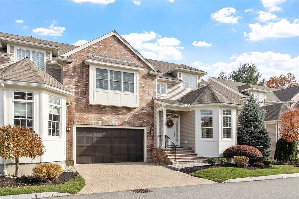 a front view of a house with a yard and potted plants