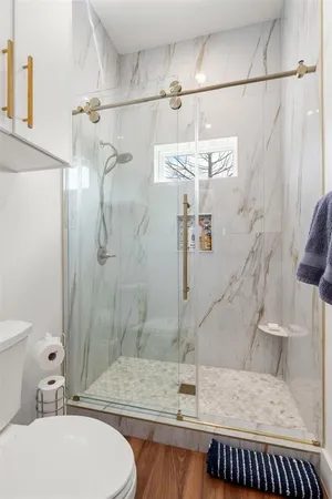 a bathroom with a granite countertop sink a toilet and shower