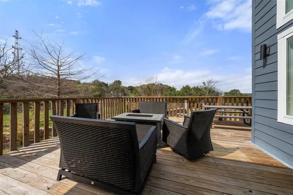 a view of a roof deck with table and chairs a barbeque with wooden floor and fence