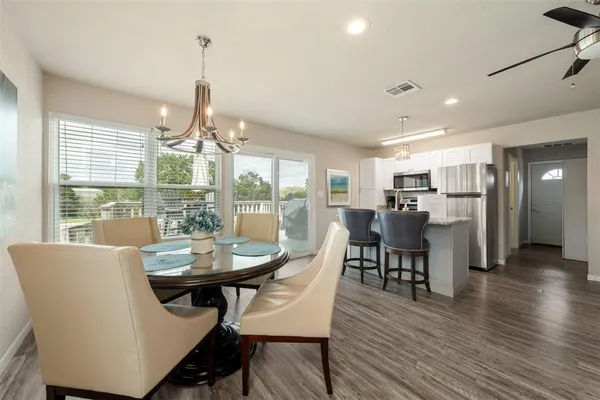 a dining room with furniture a chandelier and wooden floor