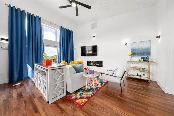 a living room with furniture windows and a wooden floor
