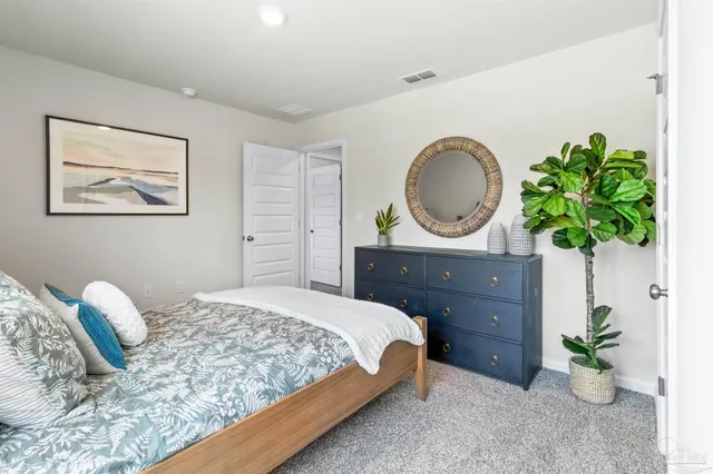 a bedroom with a bed potted plant and a dresser
