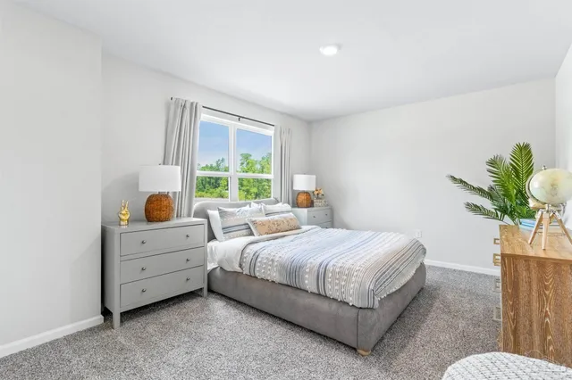 a bedroom with a bed and a potted plant