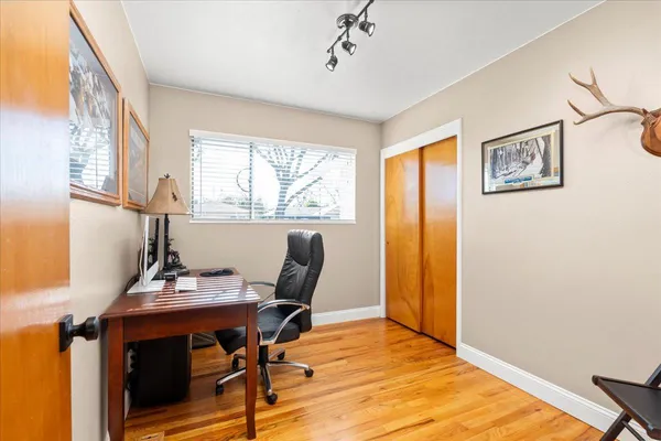a bedroom with a bed and wooden floor