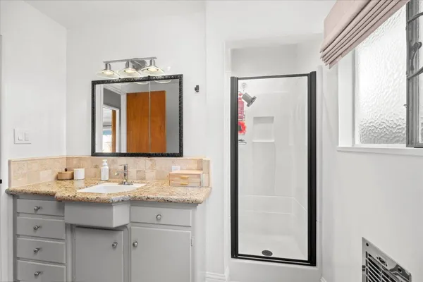 a bathroom with a granite countertop sink and a mirror