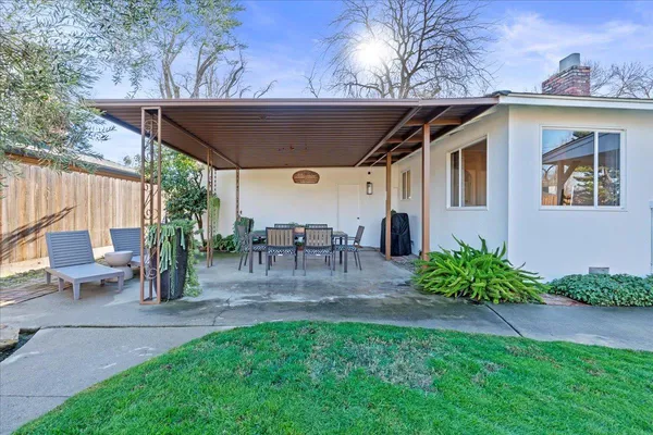a view of a house with backyard and a tree