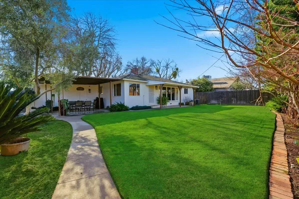 a front view of a house with a garden and trees
